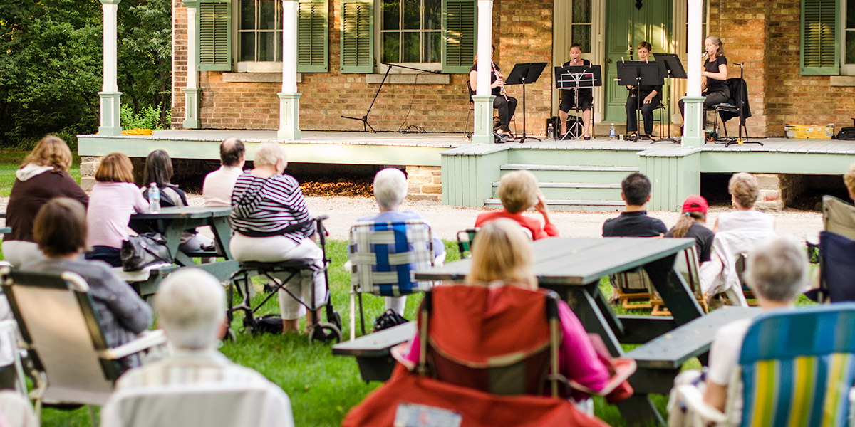 People sitting at an outdoor concert.